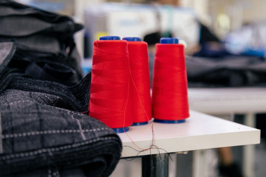 Conos de hilo junto a prendas de uniforme